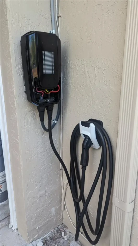 Wall-mounted electric vehicle charger installation outside a home, showcasing the convenience of home charging solutions.