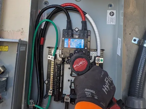 A professional electrician performing maintenance on an electrical panel in Miami Beach, ensuring safe and efficient operation of the electrical system with detailed attention to wiring and connections.