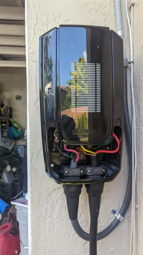 Open electric vehicle charger displaying internal wiring and components, illustrating the technology behind safe and efficient home charging.