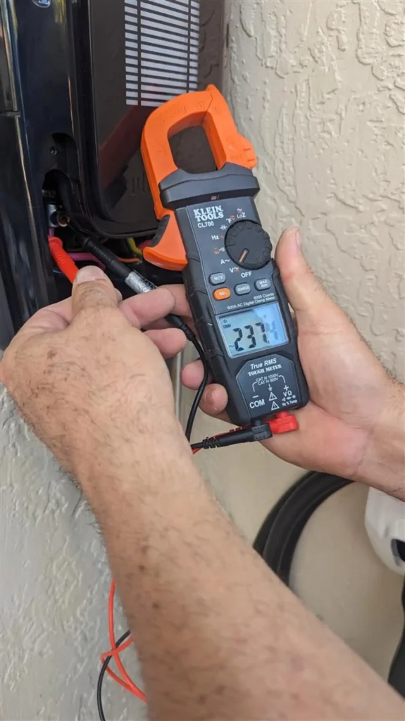 Technician using a multimeter to test an electric vehicle charger, ensuring proper installation and functionality.