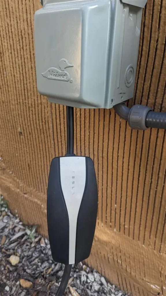 Electric vehicle charger integrated with home’s external electrical system, demonstrating a neat and professional installation.